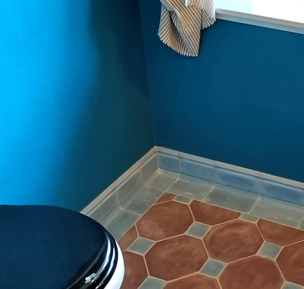 Håndlavede hulkehl hjørnefliser i marmor-cement – elegante, buede fliser for harmonisk overgang mellem væg og gulv, fremstillet i dansk design.
