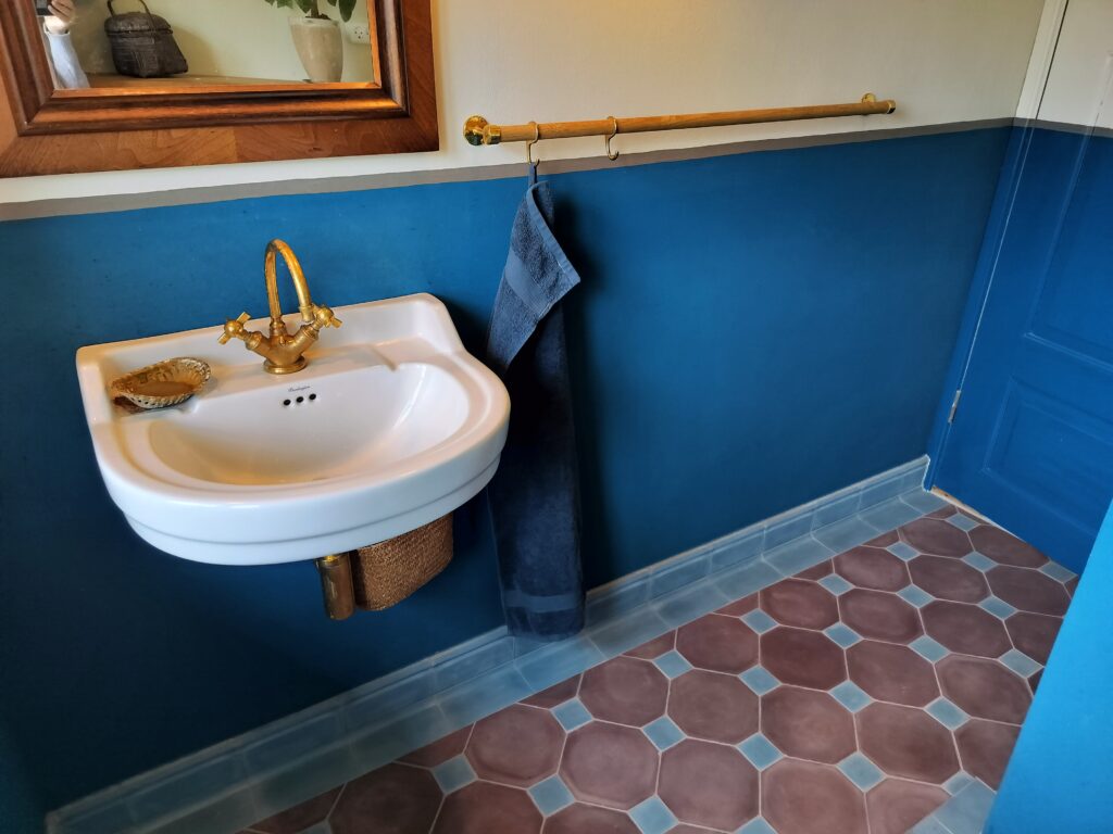 Håndlavede hulkehl hjørnefliser i marmor-cement – elegante, buede fliser for harmonisk overgang mellem væg og gulv, fremstillet i dansk design.