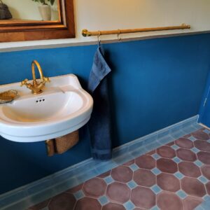 Håndlavede hulkehl hjørnefliser i marmor-cement – elegante, buede fliser for harmonisk overgang mellem væg og gulv, fremstillet i dansk design.